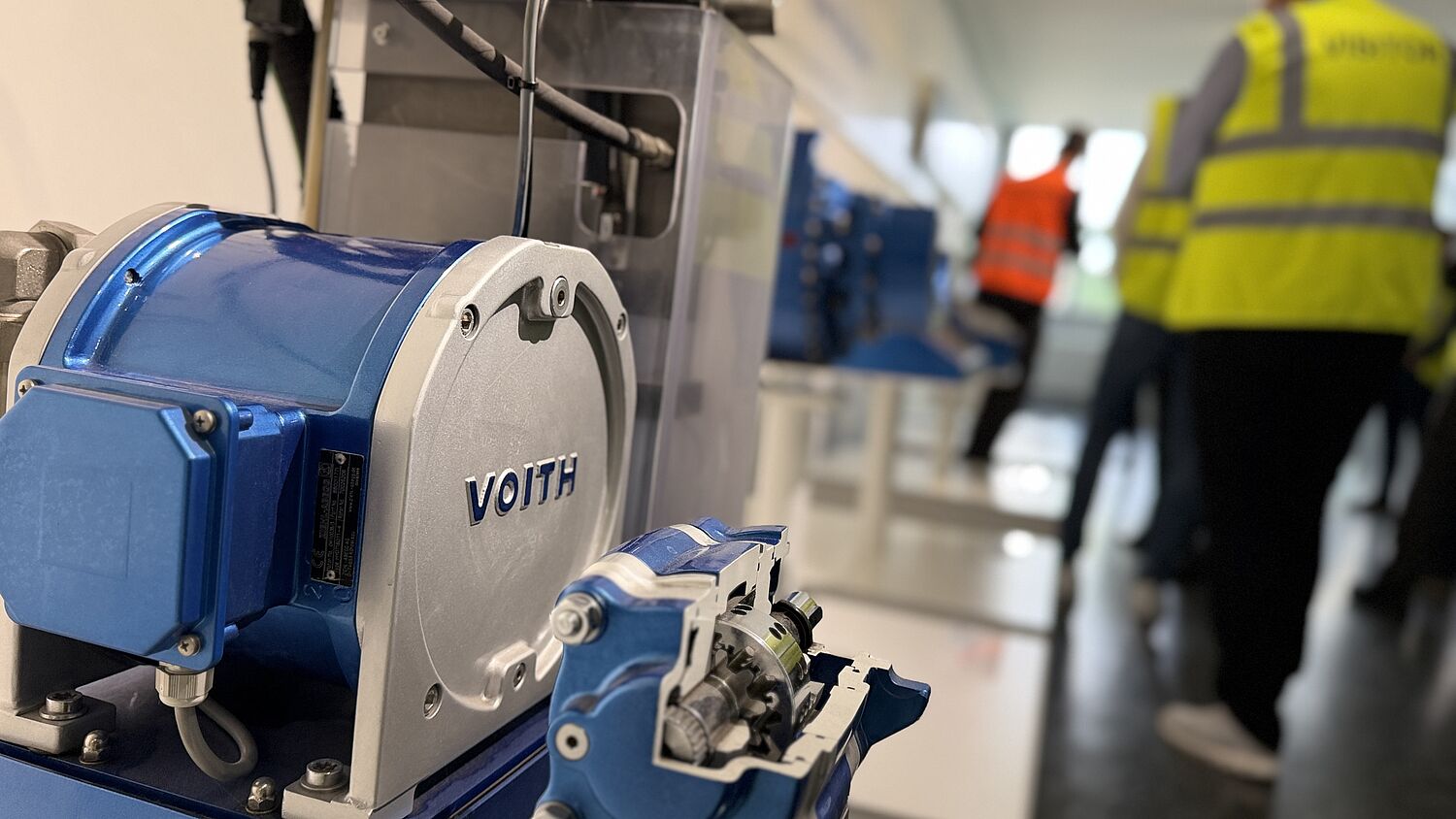 Werksführung bei Voith - Teilnehmer tragen Visitor Weste und schauen Richtung Sprecher.